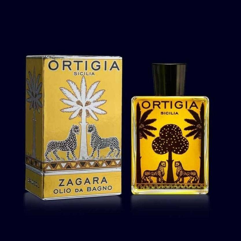 ortigia zagara bath oil in a glass bottles printed with black palm trees and leopards with its gold and silver box