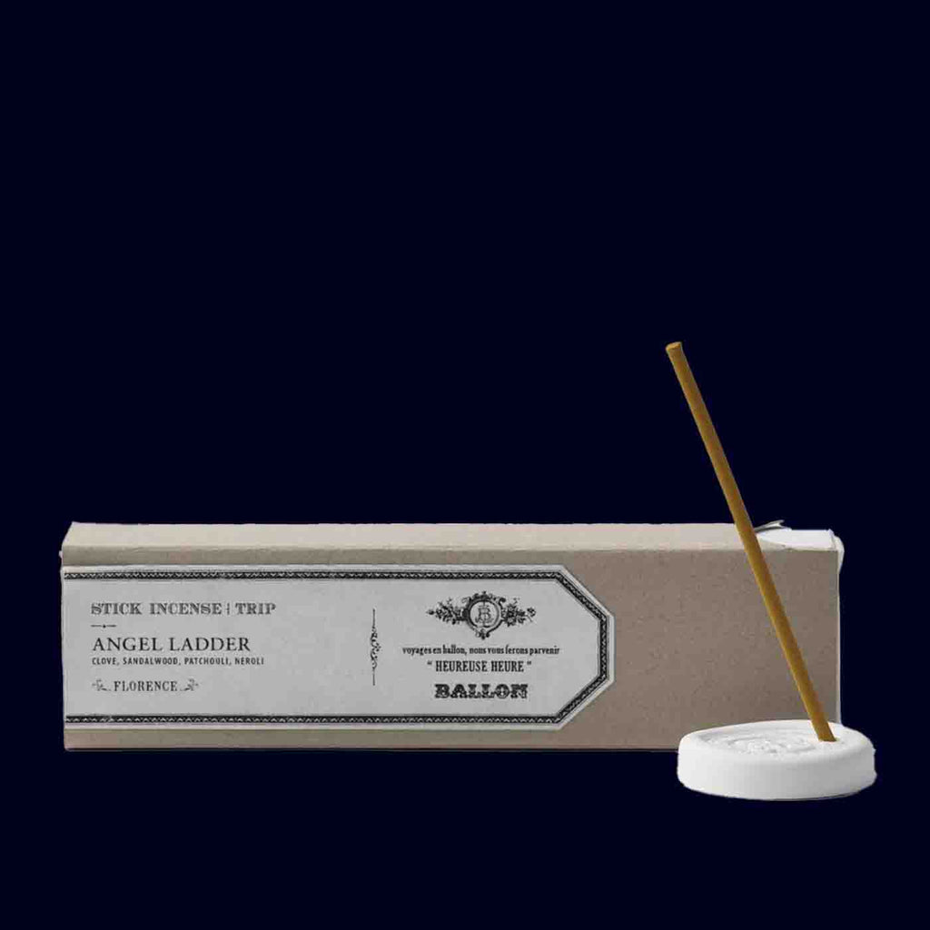 Incense stick packaging with a single incense stick on a white base against a dark background