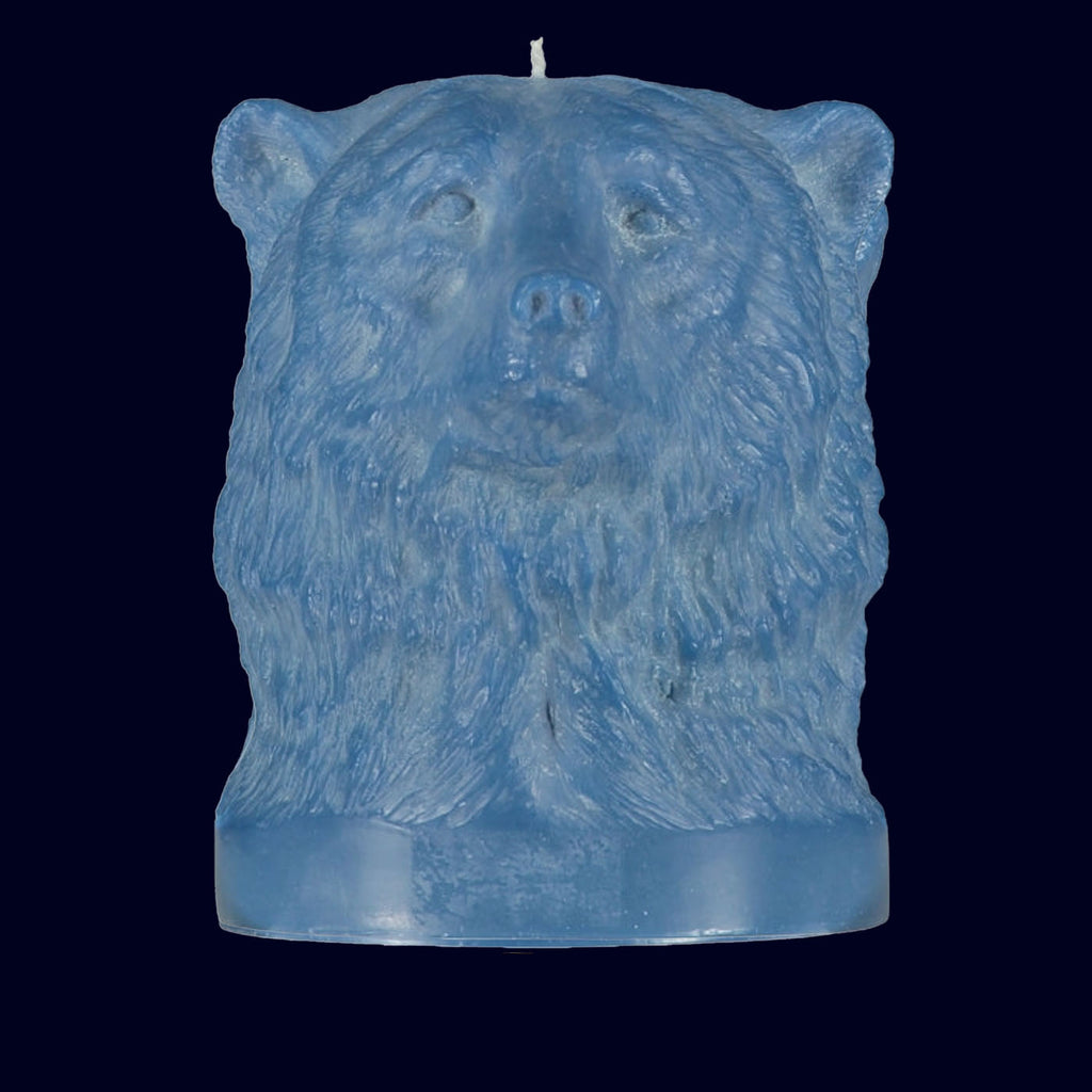 Blue bear-shaped candle on a black background