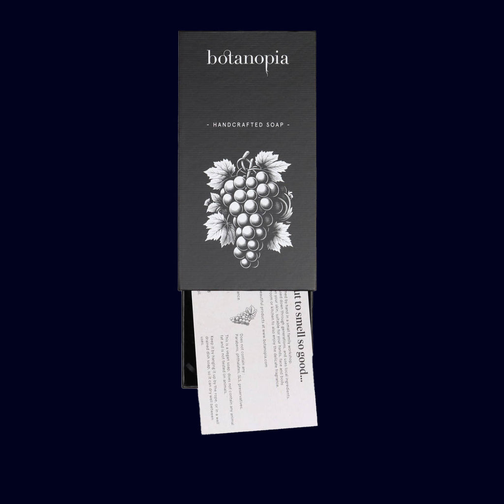 Botanopia handcrafted soap packaging with grape illustration on a black background