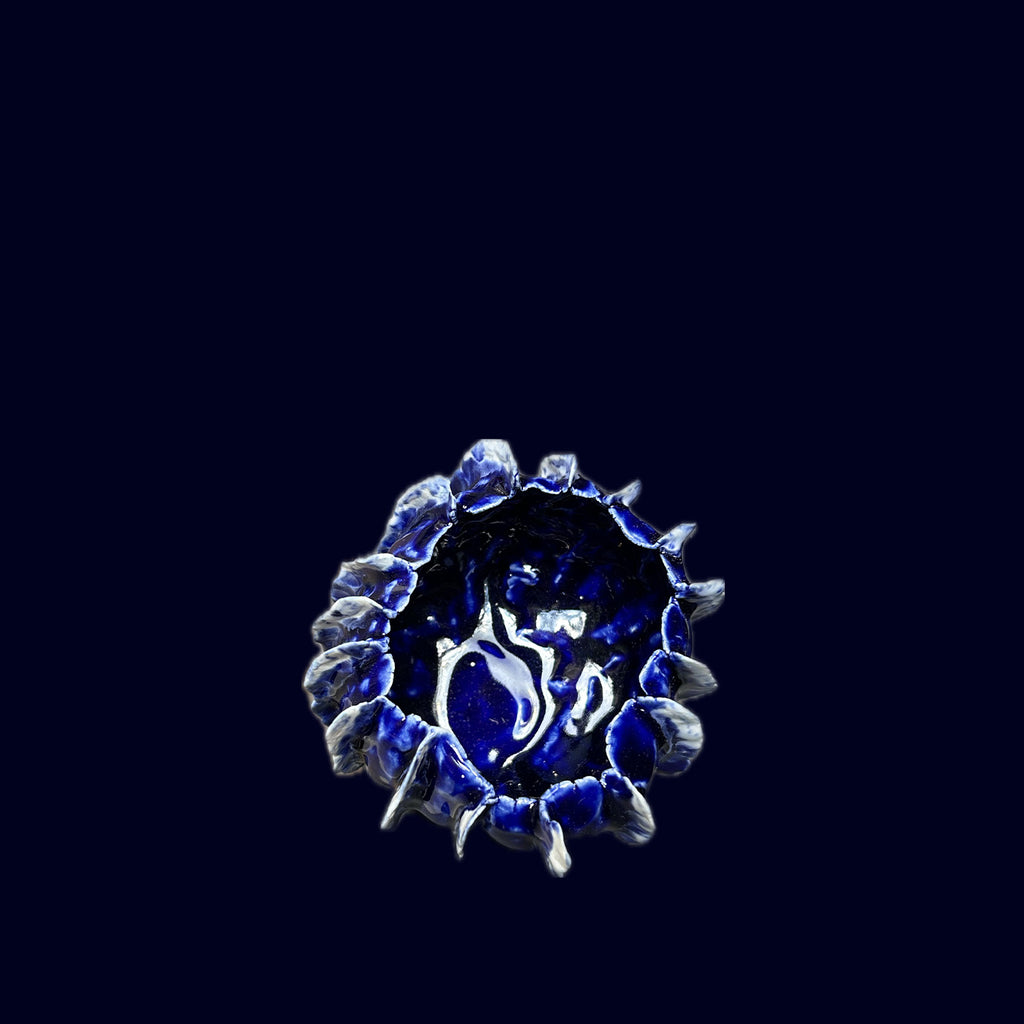 Blue decorative item with a central design on a black background