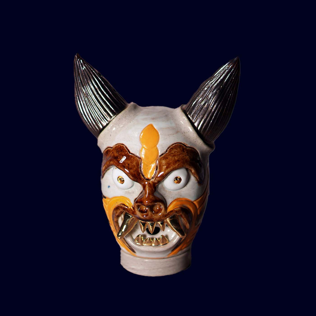 Dogabi Ceramic dog head incense burner  with gold teeth on a dark blue background