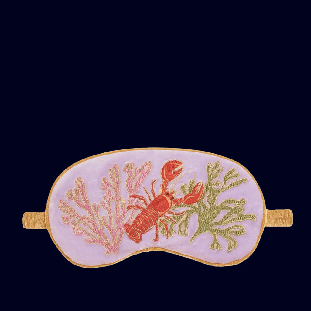 Sleep mask with lobster and coral design on a dark background