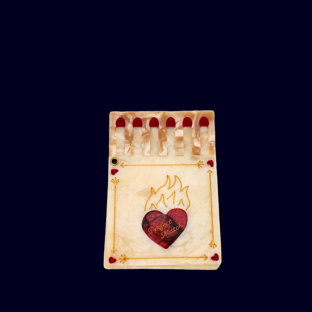Small hand mirror with a heart design on a dark background