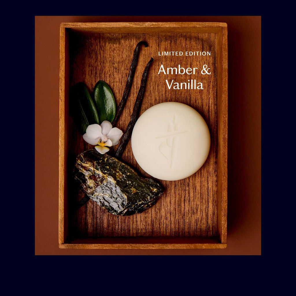 Wooden box with a hydrating bar, vanilla bean, and flowers labeled 'Limited Edition Amber & Vanilla'.