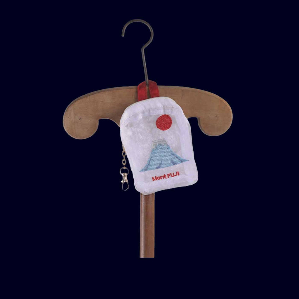 Small pouch with Mount Fuji design on a wooden hanger against a dark background