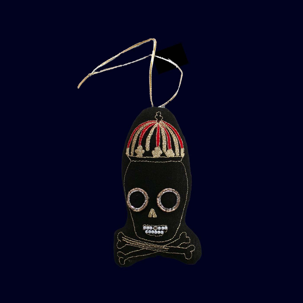 Decorative skull ornament with a red and gold headdress on a dark background