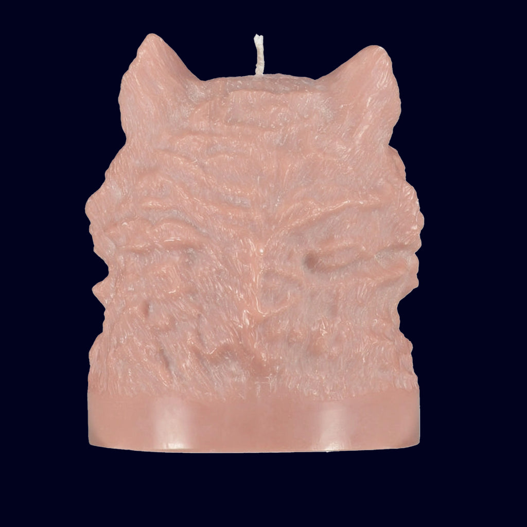 Pink candle shaped like a wolf head on a black background