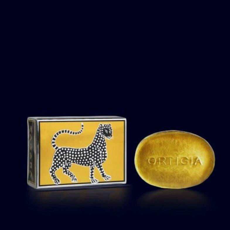 ortigia glycerin soap, honey color, and its metallic black and gold gift box ornated with a leopard-orange blossom-zagara- sicily